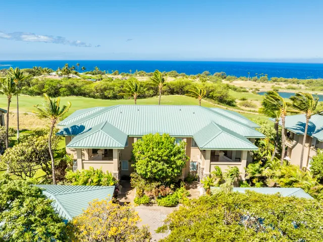 an aerial view of ocean and residential houses with outdoor space