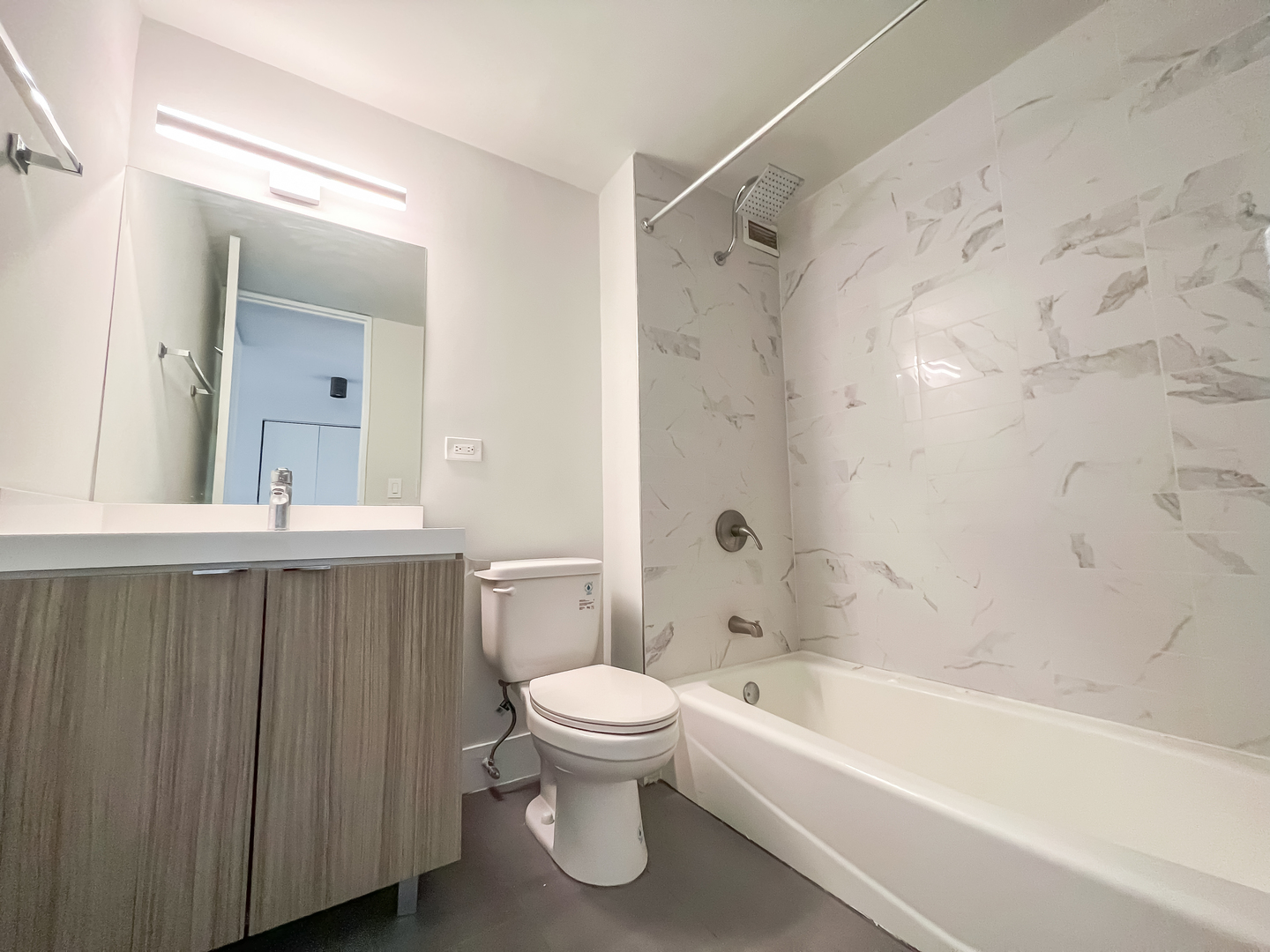 Undisclosed Address Chicago, IL 60611 - Photo 11 of 11 a bathroom with a bathtub shower sink vanity and toilet