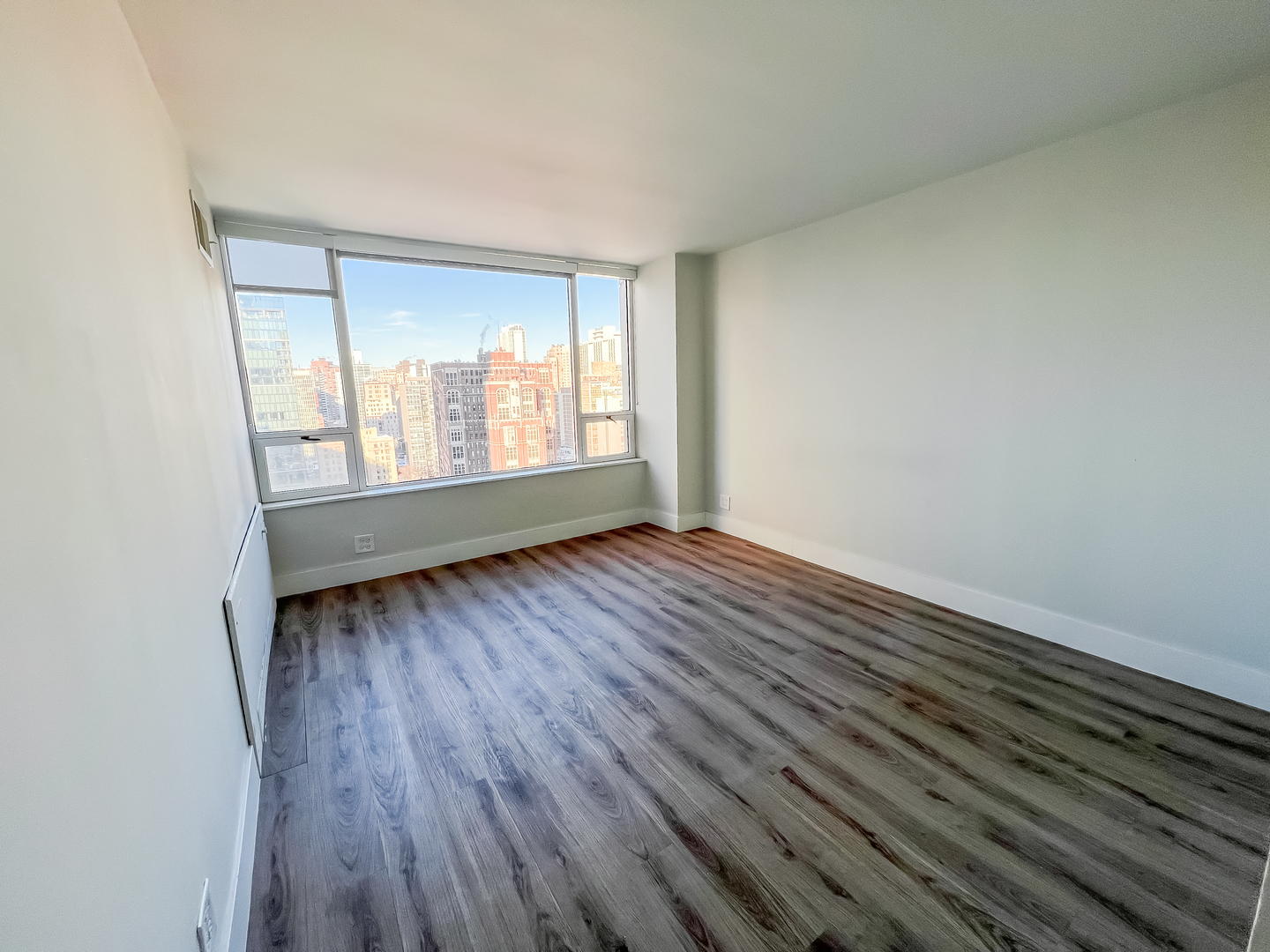 Undisclosed Address Chicago, IL 60611 - Photo 8 of 11 an empty room with wooden floor and windows