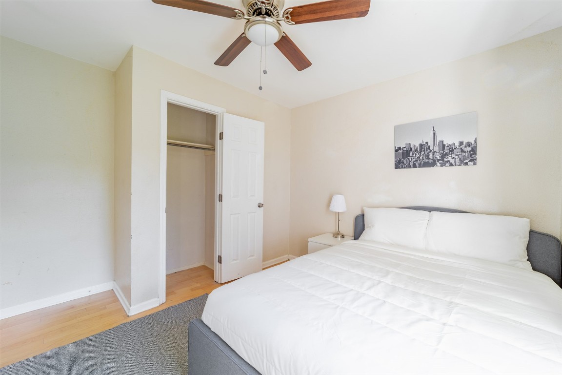 1738 Rutland Drive, Unit A Austin, TX 78758 - Photo 11 of 30 a bedroom with a large bed and a chandelier
