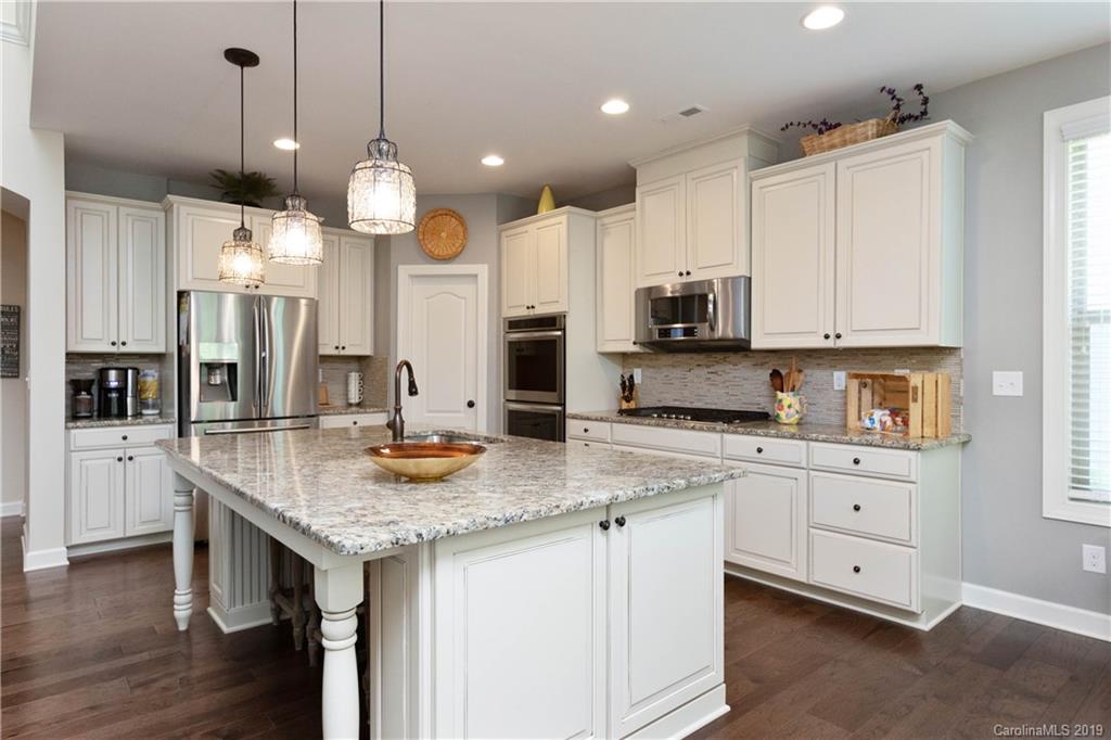 1612 Basil Court Tega Cay, SC 29708 - Photo 14 of 45 a kitchen with stainless steel appliances granite countertop a sink a stove and a refrigerator