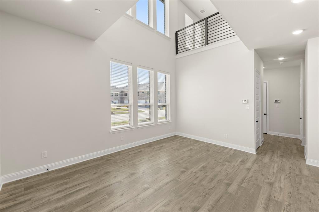 3900 Keya Drive Prosper, TX 75078 - Photo 7 of 36 an empty room with wooden floor and windows