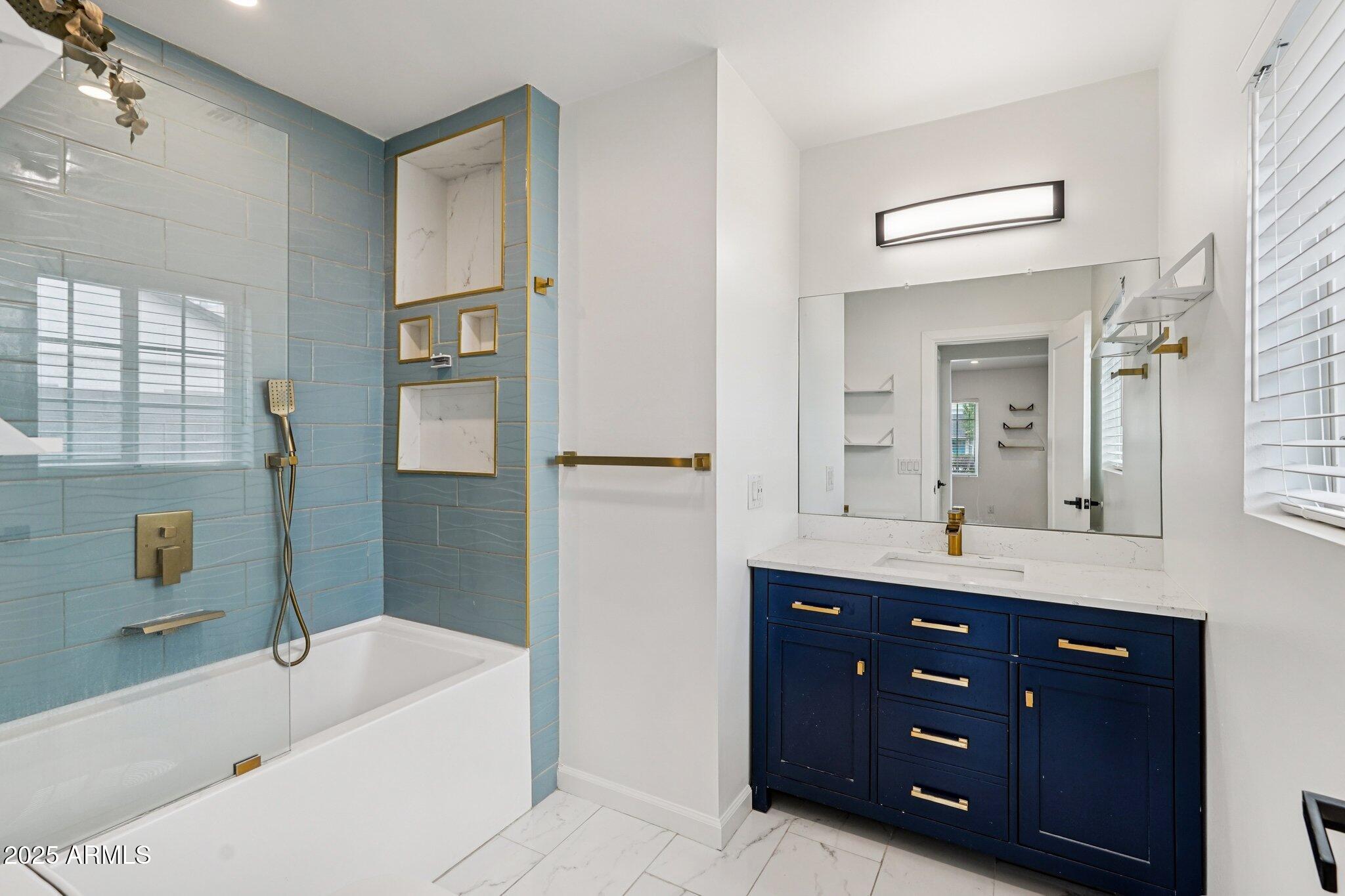 511 East Cheery Lynn Road Phoenix, AZ 85012 - Photo 15 of 33 a bathroom with a tub a double vanity sink and mirror