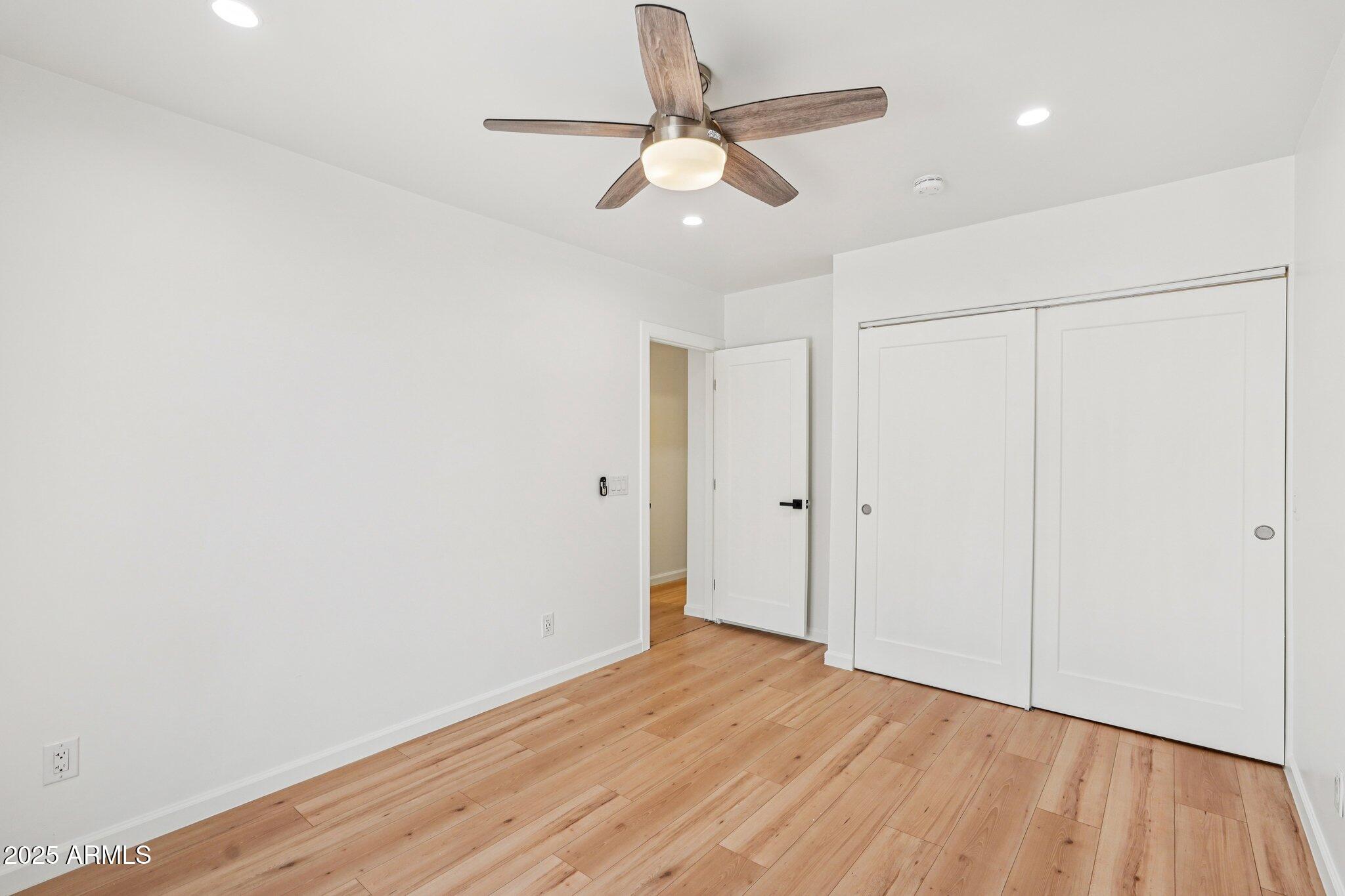 511 East Cheery Lynn Road Phoenix, AZ 85012 - Photo 20 of 33 an empty room with wooden floor fan and windows