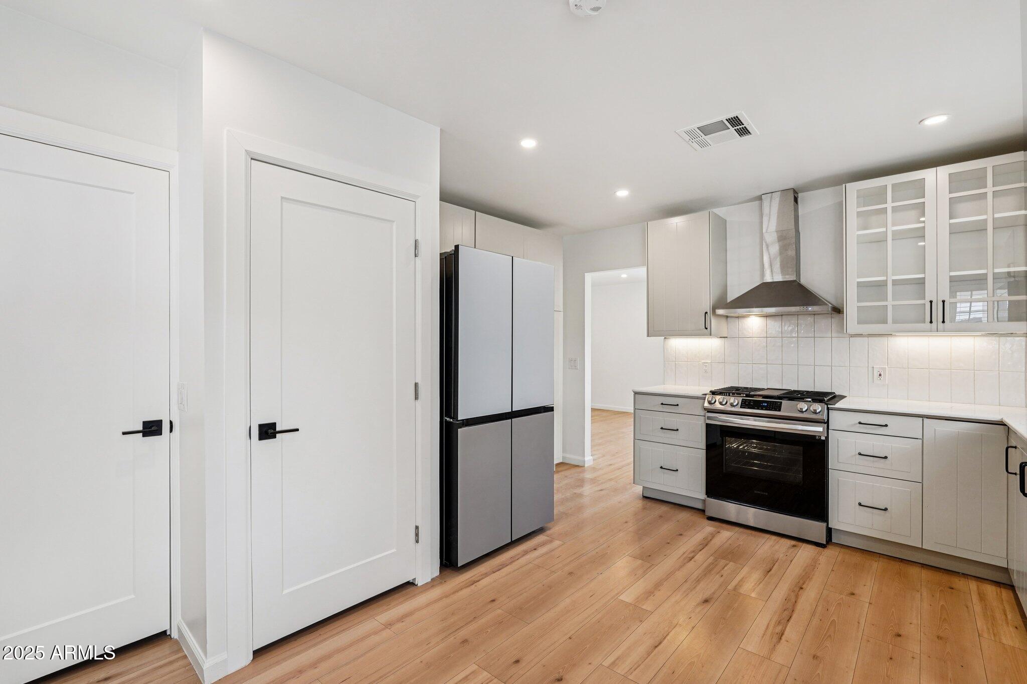 511 East Cheery Lynn Road Phoenix, AZ 85012 - Photo 7 of 33 a kitchen with granite countertop stainless steel appliances a refrigerator cabinets and wooden floor