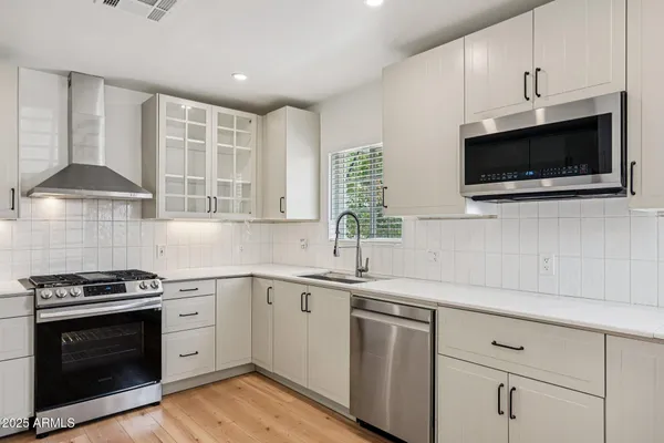 a kitchen with granite countertop white cabinets and stainless steel appliances
