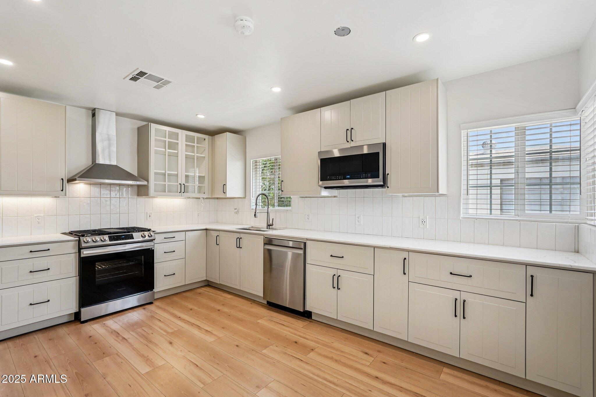 511 East Cheery Lynn Road Phoenix, AZ 85012 - Photo 9 of 33 a kitchen with granite countertop white cabinets and stainless steel appliances