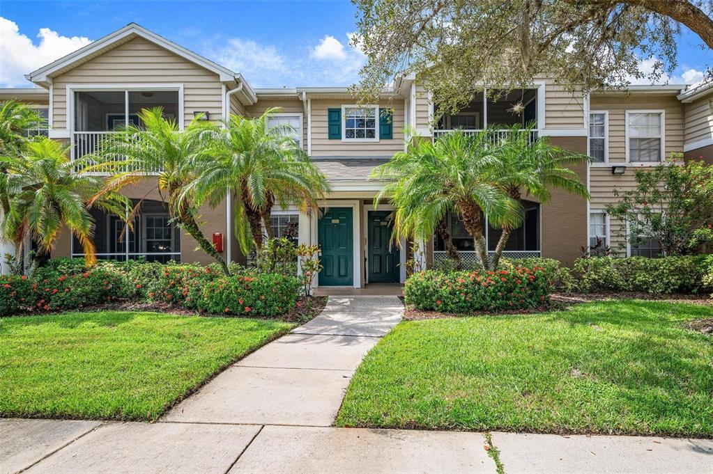 a front view of a house with a yard and potted plants