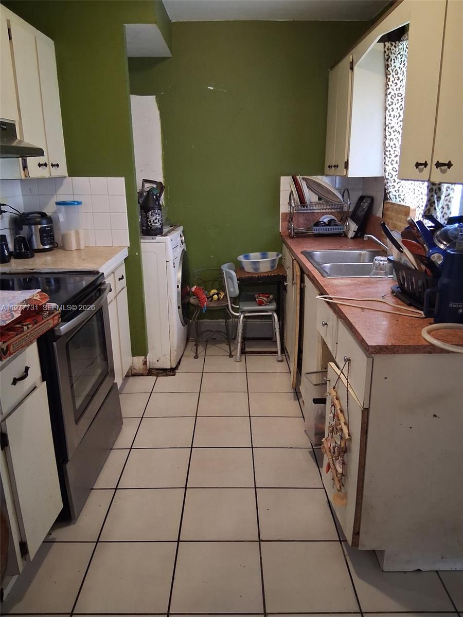 960 Southwest 13th Court Miami, FL 33135 - Photo 11 of 15 a kitchen with a sink a stove and a refrigerator