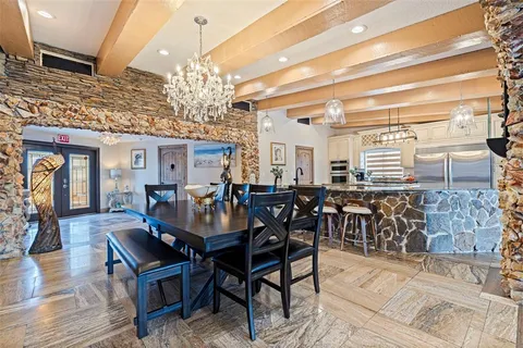 a kitchen with a dining table chairs and chandelier