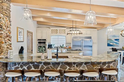 a kitchen that has a lot of cabinets a sink and a stove