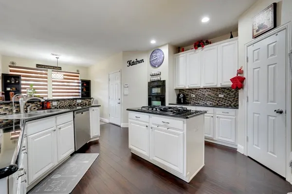 a kitchen with stainless steel appliances granite countertop a sink and cabinets