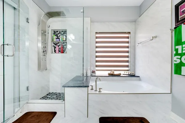 a bathroom with a granite countertop bathtub and shower