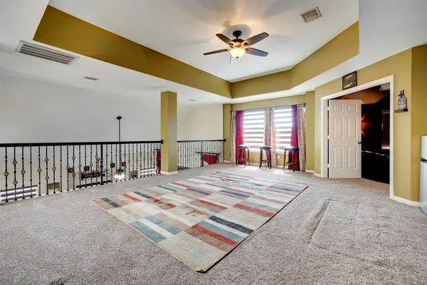 a spacious bedroom with a large bed and a chandelier