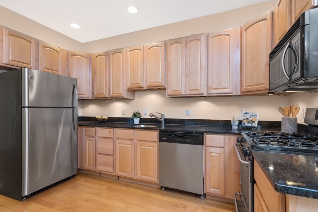 8 Howell Street, Unit 1 Boston, MA 02125 - Photo 2 of 14 a kitchen with stainless steel appliances granite countertop a refrigerator a stove a sink and white cabinets