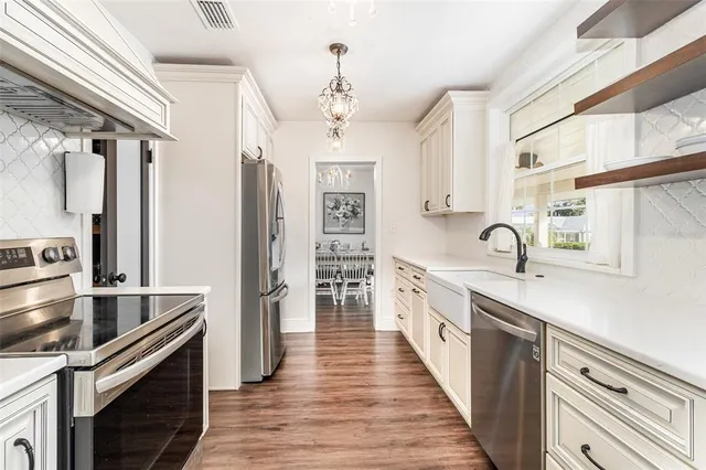 a kitchen with stainless steel appliances sink a stove and cabinets