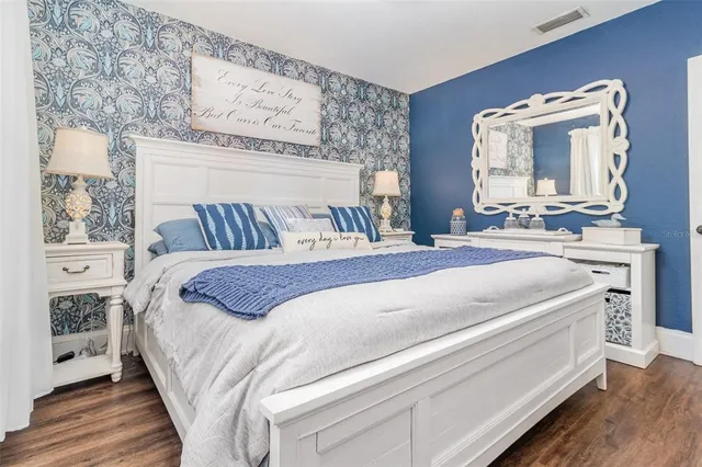 a spacious bedroom with a bed and a mirror