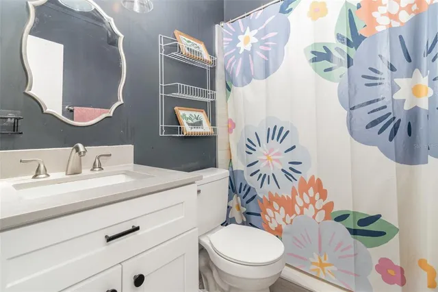 a bathroom with a sink a toilet and a mirror
