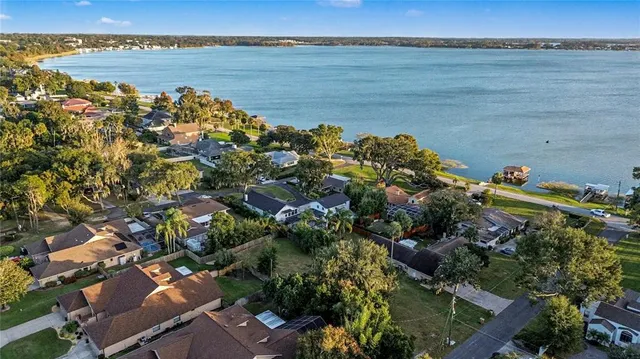 an aerial view of a house with swimming pool a yard and lake view