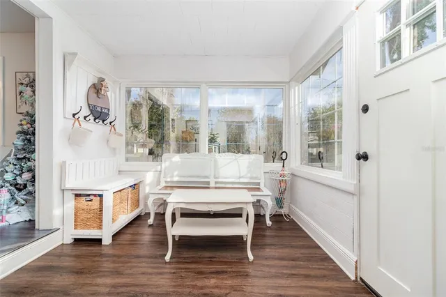 a living room with furniture a wooden floor and next to a window