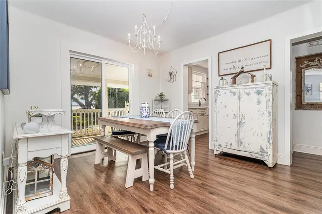 a dining room with furniture a chandelier and wooden floor