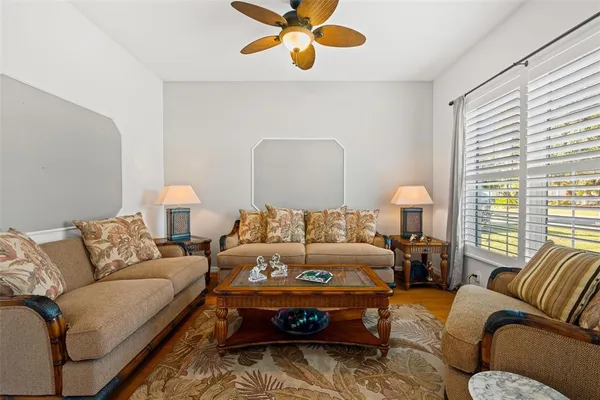 a living room with furniture ceiling fan and a window