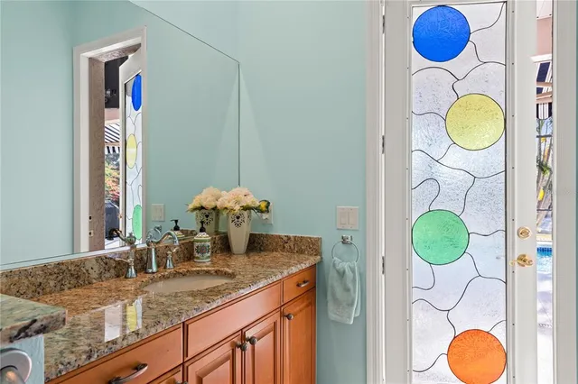 a bathroom with a granite countertop sink and a mirror