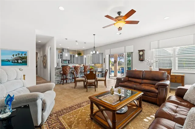 a living room with furniture kitchen view and a large window