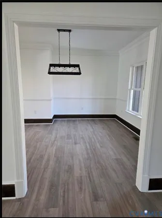 a view of a room with wooden floor and white walls
