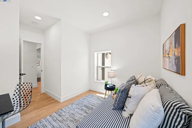 a kitchen with stainless steel appliances granite countertop a refrigerator a sink dishwasher a stove and white cabinets with wooden floor