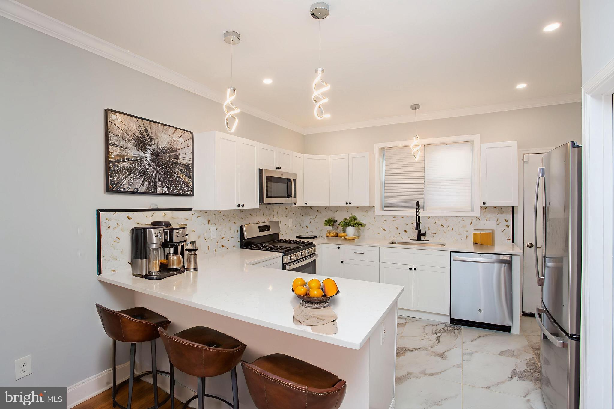 a kitchen with stainless steel appliances a refrigerator sink and white cabinets