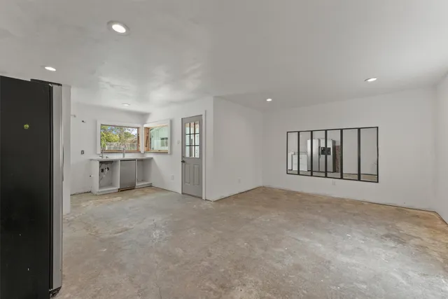an empty room with windows and cabinet