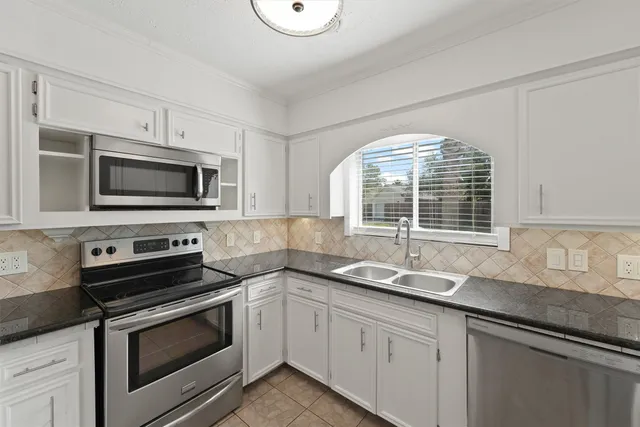 a kitchen with stainless steel appliances a stove microwave and sink