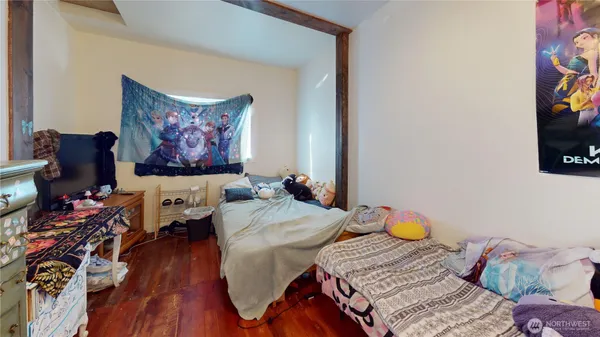 a bedroom with a bed and wooden floor