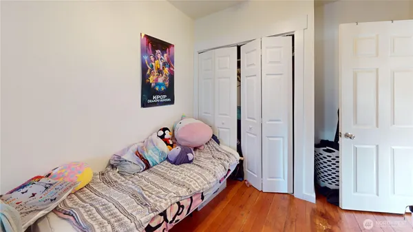 a bedroom with a bed and wooden floor