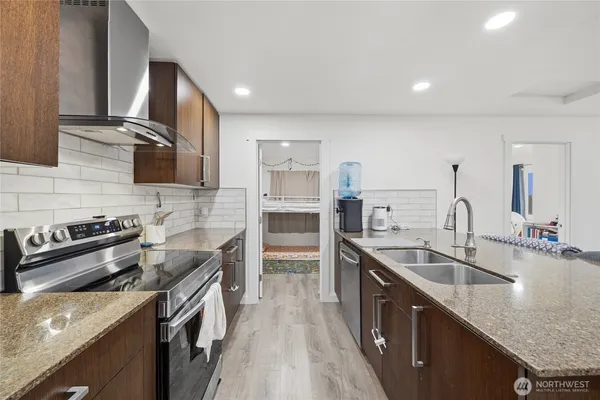 a kitchen with stainless steel appliances granite countertop a sink stove and refrigerator