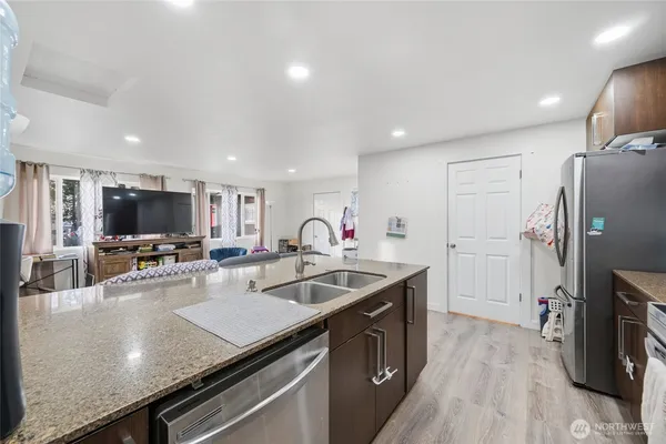 a kitchen with stainless steel appliances granite countertop a sink a stove and a refrigerator