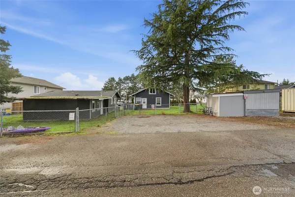 a view of road with house and trees in the background