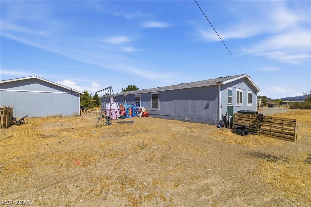 4331 Retread Road Pahrump, NV 89048 - Photo 23 of 31 A manufactured home with a spacious yard offers room for outdoor activities under a wide sky.