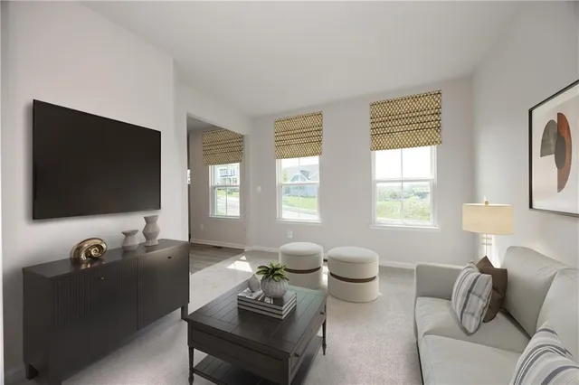 a living room with furniture a flat screen tv and a window