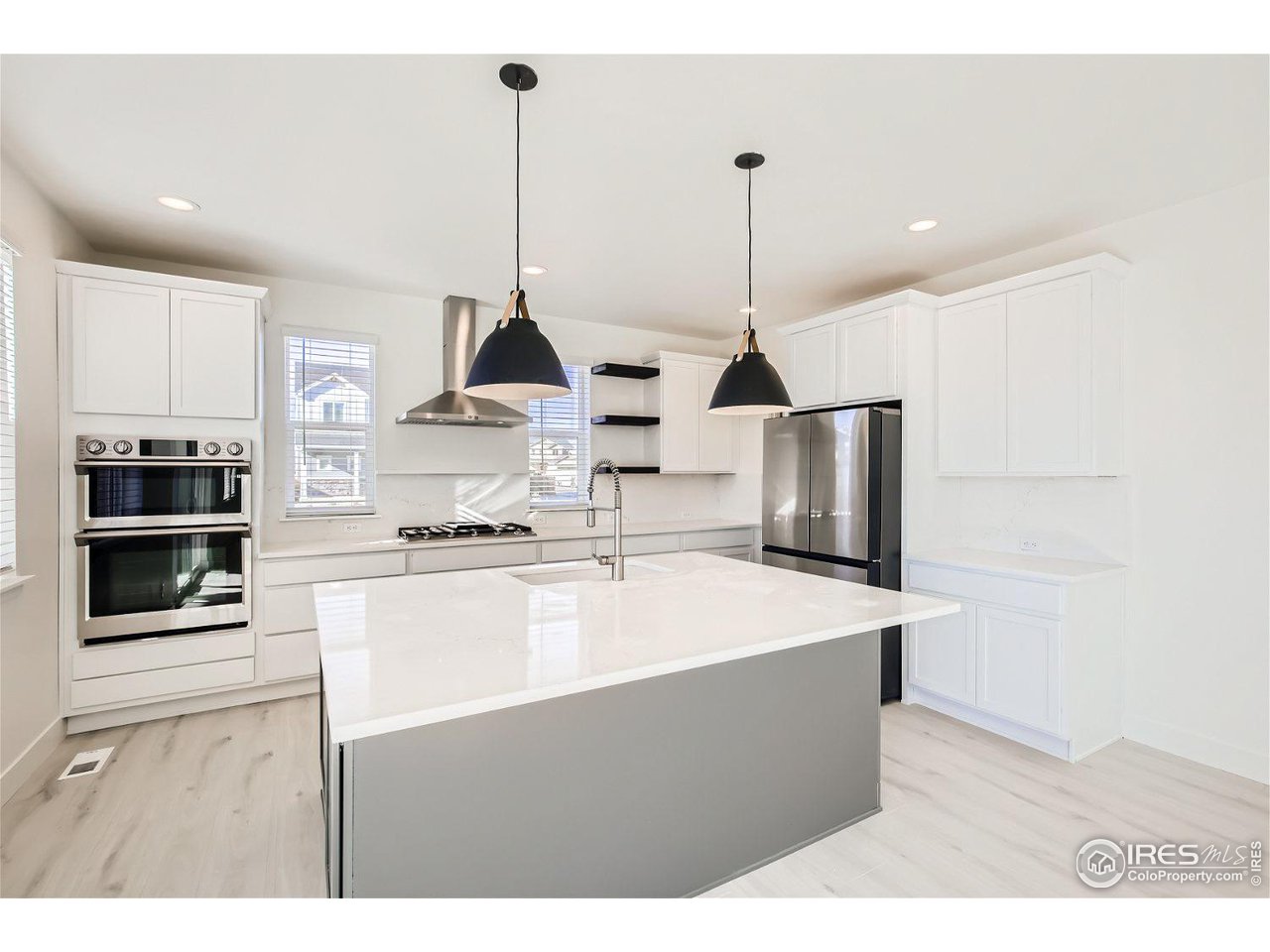 a kitchen with stainless steel appliances kitchen island granite countertop a sink a stove and a refrigerator