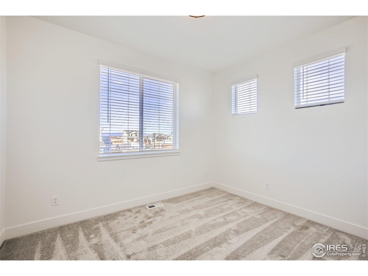 335 Boxwood Drive Windsor, CO 80550 - Photo 11 of 23 an empty room with wooden floor and windows