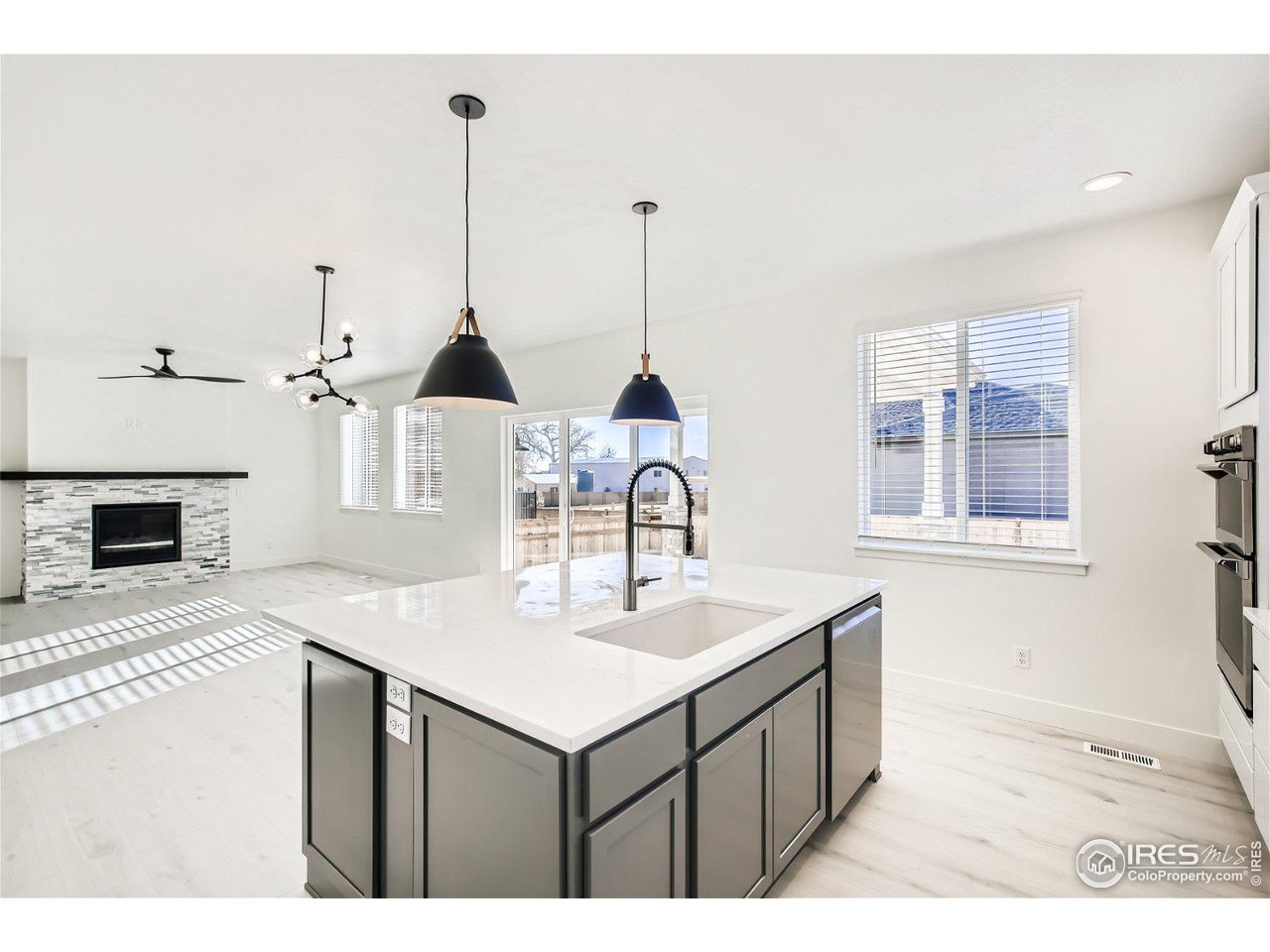 335 Boxwood Drive Windsor, CO 80550 - Photo 6 of 23 a kitchen with a sink a chandelier and wooden floor