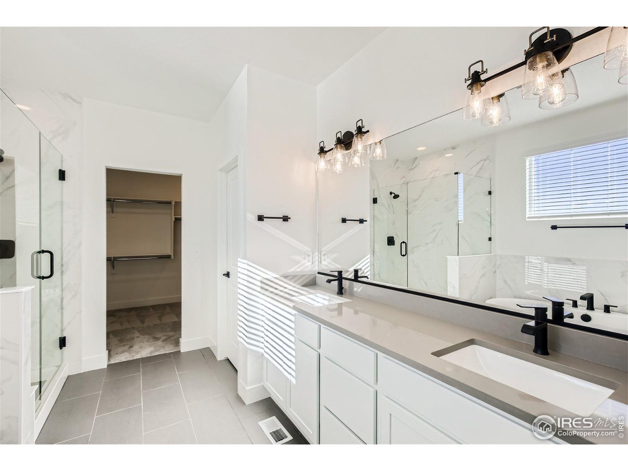 335 Boxwood Drive Windsor, CO 80550 - Photo 9 of 23 a en suite bathroom with a double vanity sink a mirror and a shower