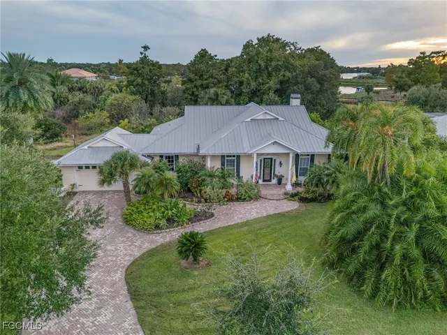 an aerial view of a house with yard and green space