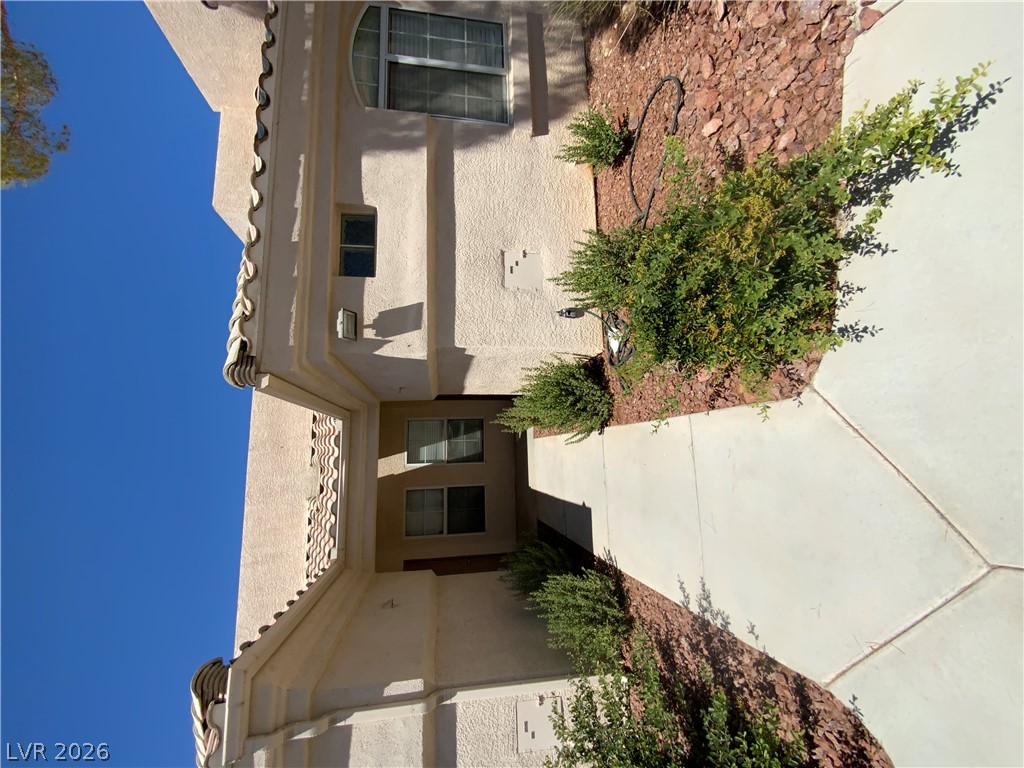 7400 West Flamingo Road, Unit 1039 Las Vegas, NV 89147 - Photo 2 of 40 A terracotta-tiled roofline crowns this building, showcasing a textured facade and well-tended landscaping.