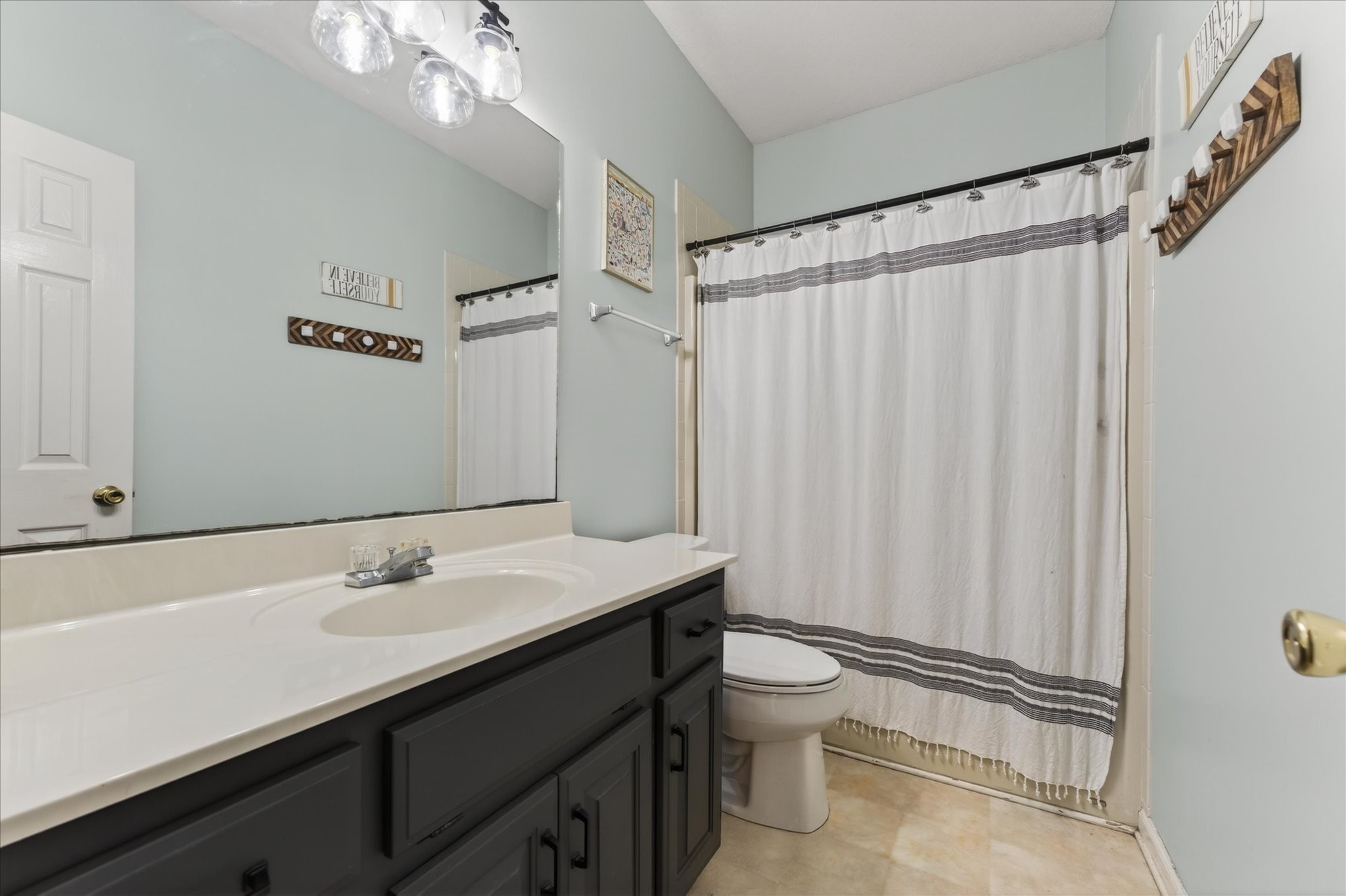 200 Cheshire Road Clarksville, TN 37043 - Photo 23 of 33 a bathroom with a sink a toilet a mirror and shower curtain