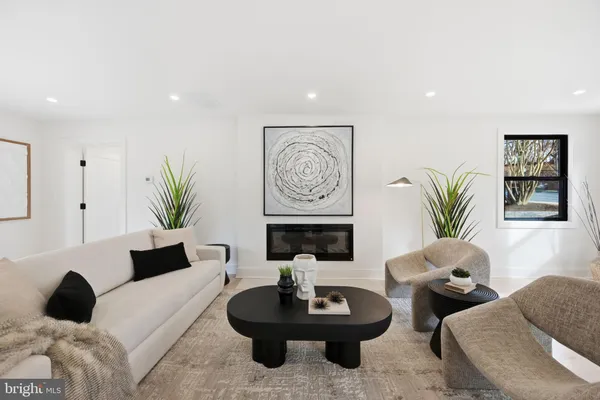 a living room with furniture potted plant and a wooden floor