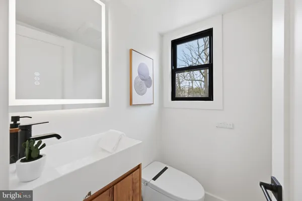 a bathroom with a toilet sink and mirror