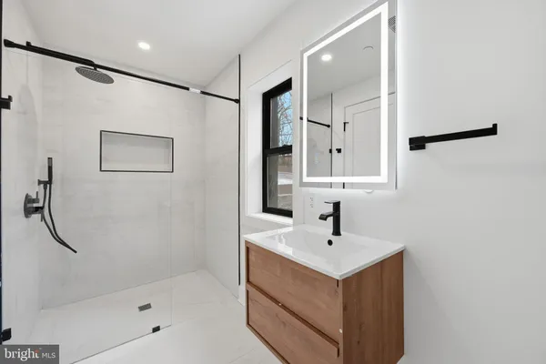 a bathroom with a shower sink and mirror
